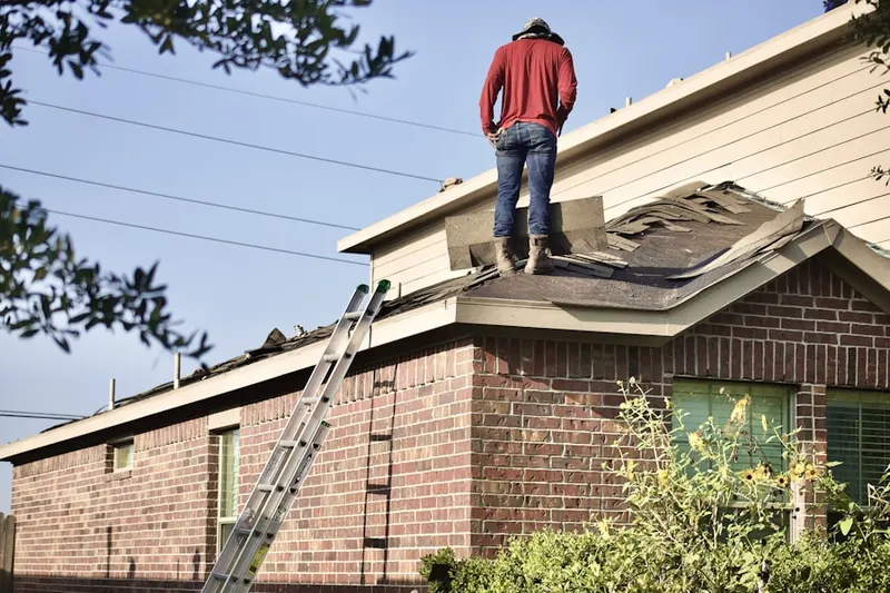 Professional roofer working on a residential roof in Tolles